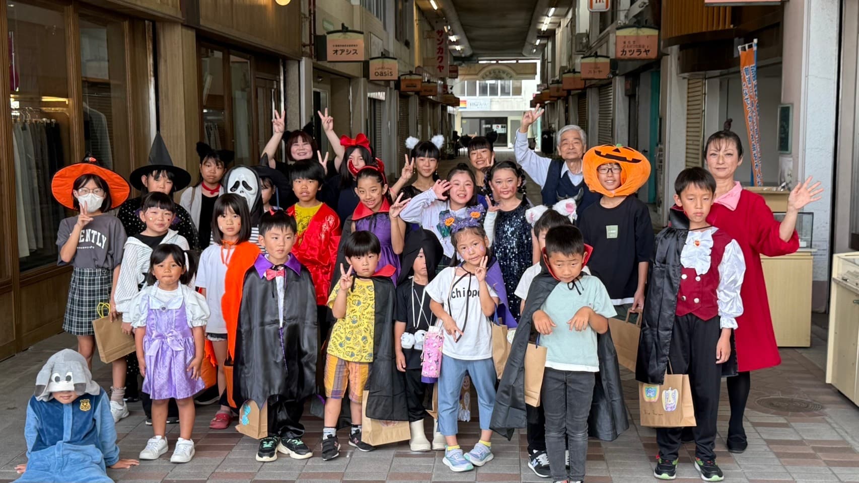 ハロウィン仮装パレード — 大牟田の商店街を歩く生徒たちと先生たち